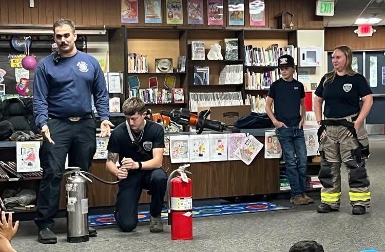 Volunteer Fire Fighters showing students at local schools how to use a fire extinguisher 